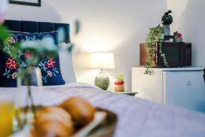 a bedroom with a bed with a television and plants at Victoria Park Studio 11 - Free Parking, WiFi, Near Town Centre, Free DisneyPlus, Prime & Netflix in Leamington Spa