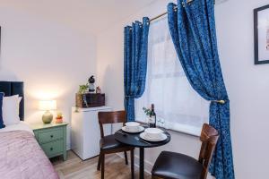 a bedroom with a table and chairs and a bed at Victoria Park Studio 11 - Free Parking, WiFi, Near Town Centre, Free DisneyPlus, Prime & Netflix in Leamington Spa
