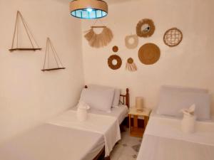 two beds in a room with hats on the wall at Maliag Studio Type Room for Rent in Coron