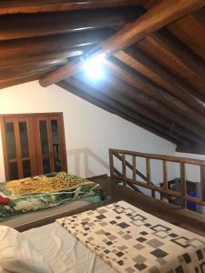 two beds in a room with wooden ceilings at chalé da reserva com piscina in Torres