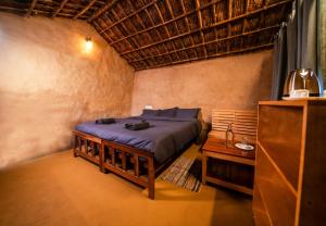 une chambre avec un lit et une table dans une pièce dans l'établissement Snow Smile Camps Munnar, à Munnar