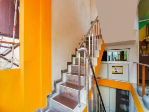 a staircase in a building with orange and yellow walls at Hotel O Classic Grand Residency in Puducherry