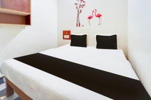 a bedroom with a large bed with two flamingos on the wall at Hotel O Classic Grand Residency in Puducherry +30 photos