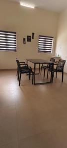 a table and chairs in a room with two windows at Aura Villa in Kozhikode +9 photos