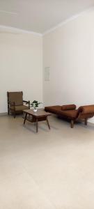 two wooden benches and a table in a room at Aura Villa in Kozhikode