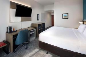 a hotel room with a bed and a desk and a computer at Comfort Inn & Suites Dahlonega University Area in Dahlonega