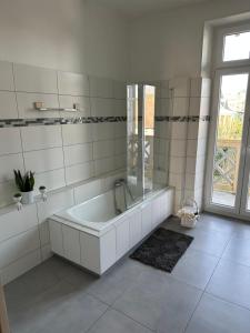 a white bathroom with a tub and a window at Jardin de Victor Appartements calmes spacieux avec jardin clos in Belfort +29 photos