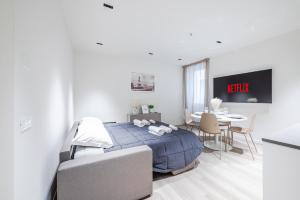 une chambre avec un lit et une table avec des chaises dans l'établissement Arnaldo Apt Luxury e Design in Duomo, à Brescia