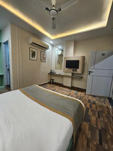 Una habitación de hotel con una cama grande y un televisor. en Dashrath Inn near Ramjanmbhoomi, en Ayodhya