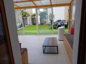 a living room with a table and a view of a patio at Grand T4 Terrasse proche sanctuaire in Lourdes +3 photos