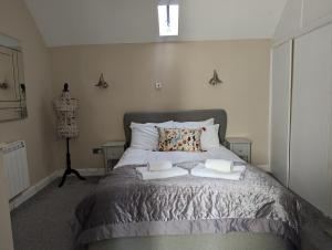 a bedroom with a bed with two towels on it at The Courtyard Apartment at Cefn Tilla Court, Usk in Usk