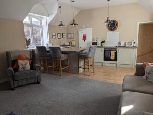 a kitchen and living room with a table and chairs at The Courtyard Apartment at Cefn Tilla Court, Usk in Usk