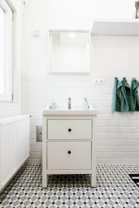 a bathroom with a white sink and a black and white floor at Ferienwohnung Meersburg 30m vom Bodensee in Meersburg