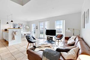 a living room with a couch and a tv at Charming Terraced House By The Beach And Forest in Bro