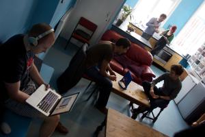 eine Gruppe von Personen in einem Wohnzimmer mit einem Laptop in der Unterkunft Dover Castle Hostel in London