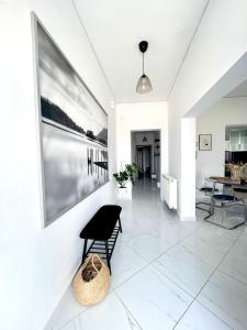 a white living room with a black chair on a tile floor at Villa Thea in Makri +11 photos