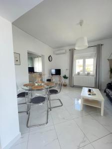 a white living room with a table and chairs at Villa Thea in Makri