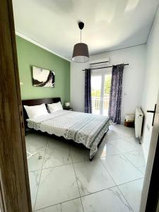 a bedroom with a bed with green walls and a window at Villa Thea in Makri
