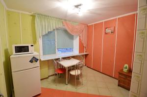 uma pequena cozinha com uma mesa e um frigorífico em Apartment Style on Sobornaya Street em Nikolayev