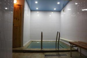 una piscina in una stanza con porta in legno di Lavitor hotel a Bishkek
