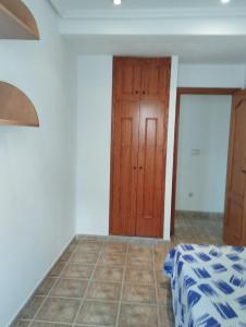 a bedroom with a bed and a wooden door at Torrevieja Centro in Torrevieja +5 photos