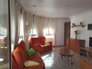 a living room with a red couch and a table at Torrevieja Centro in Torrevieja