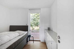a bedroom with a large bed and a window at Holiday Home On Bornholm Close To Sea And Beach in Vester Sømarken