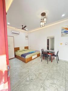 a bedroom with a bed and a table and chairs at GRAYSTONE HOMESTAY, Omassery in Tāzhekkod