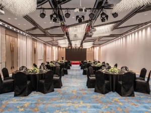 苏州苏州中惠铂尔曼酒店的有桌椅和屏风的宴会厅 更多37张照片