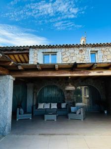 an outdoor patio with a couch on a stone building at Villa Grazia in Cala Sinzias +22 photos