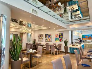 a restaurant with tables and chairs in a room at Club House Hotel in Rimini