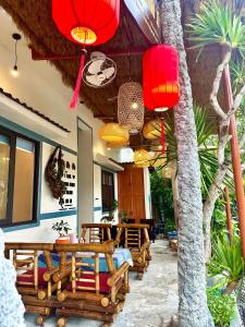 a patio with wooden tables and red lanterns at Homestay Ngô Khánh 1 in Cù Lao Chàm