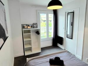 a room with a bed and a large window at L'Atelier-T2 proche du centre-Wifi-Parking in Lourdes