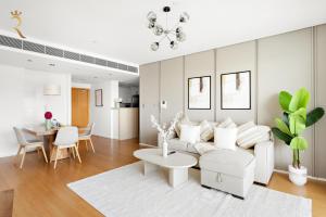 a living room with a white couch and a table at Oasis Stylish 2BR in Al Rahba - Modern Stay Near Al Raha Beach & Yas Island in Yas Island