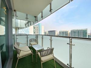 two chairs and a table on a balcony with a city skyline at Oasis Stylish 2BR in Al Rahba - Modern Stay Near Al Raha Beach & Yas Island in Yas Island