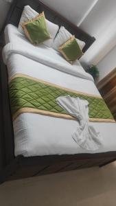 a bed with a green and white comforter on it at 3 bhk near lulu mall kochi in Cochin +17 photos