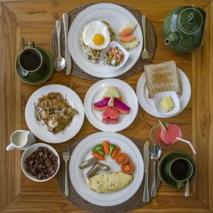 einen Tisch mit Frühstücksteller darauf in der Unterkunft Sapodilla Ubud in Ubud