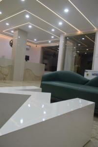 a room with a white table and green chairs at Hotel Magnet in Indore