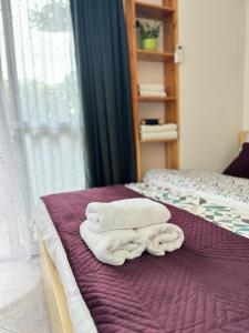 two towels are stacked on a bed in a room at Studioo Apartment in Tirana