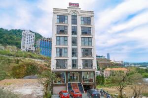a tall building with cars parked in front of it at Ngan Ha Hotel Tam Dao Panorama View in Tam Ðảo