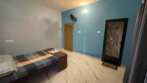 a bedroom with a bed and blue walls at Olive Homestays in Varkala