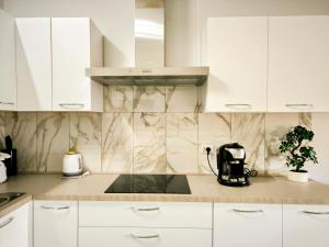 a kitchen with white cabinets and a counter top at Castelsardo Appartment in Castelsardo