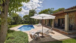 a patio with an umbrella and chairs and a pool at Correfoc ETV2963 Ubac Pollença in Sa Pobla