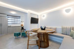 a living room with a table and a couch at Santorini Garden Homes in Mesaria
