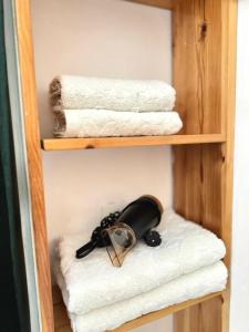 a wooden shelf with towels and a bottle on top at Studioo Apartment in Tirana +38 photos