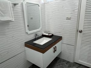 a bathroom with a sink and a mirror at Dusita Residence in Bangkok