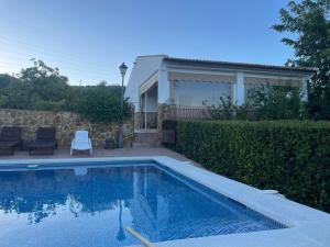 a swimming pool in front of a house at Finca Fuente la Parra in Lucena