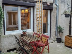 a wooden table and two chairs in front of a window at Appartement chaleureux 2ch 3lits Orléans centre in Orléans