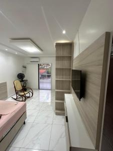 una camera da letto con un letto e una TV a schermo piatto di Casa em Ipioca a Maceió