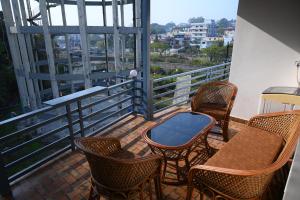 a balcony with chairs and a table and some windows at Doon Classic A in Rājpur